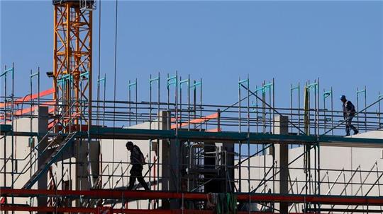 Handwerker arbeiten am Neubau eines Mehrfamilienhauses.