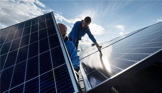 Handwerker montieren Photovoltaikmodule auf dem Dach eines Wohnhauses. Photovoltaik soll auch im Alten Land auf die Dächer. Symbolfoto: Marijan Murat/dpa