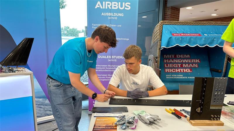 Hanna Stemmer erklärt einem Interessierten das Befestigen von Nieten. Eine Standardbeschäftigung im Flugzeugbau.