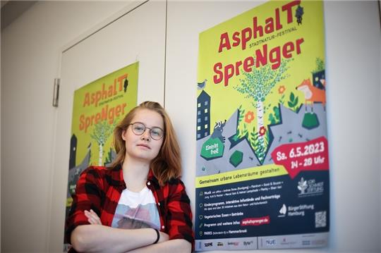 Hannah Gürtler, Freiwillige im FSJ-P (Freiwilliges Soziales Jahr Politik), lehnt neben einem Plakat in einem Büro in den Räumen der BürgerStiftung Hamburg. Ab Herbst 2023 verdoppeln sich die Plätze für ein Freiwilliges Soziales Jahr in Politik und Demokratie in Hamburg. Foto: Christian Charisius/dpa