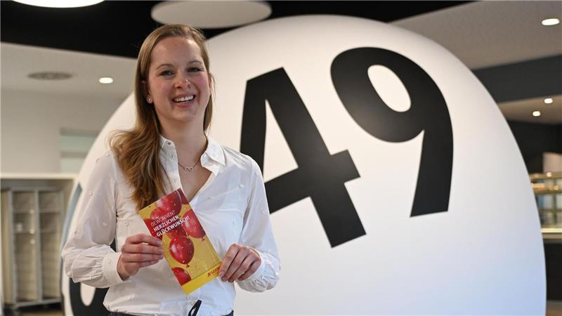 Hannah Strobel von Lotto Niedersachsen zeigt eine Broschüre für Lottogewinner.