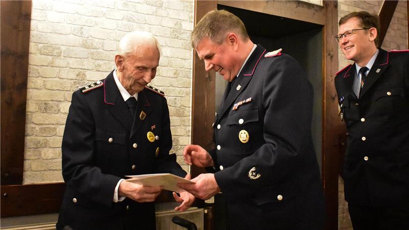 Hans-Joachim Tomfohrde (links) erhält von Gemeindebrandmeister Heiko Wachlin (Mitte) seine Mitgliedsurkunde.