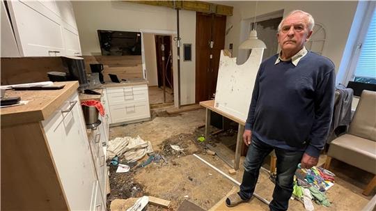 Hans-Wilhelm Vagts steht in seiner verwüsteten Küche. In der Spüle landete ein Reifen, das Fenster am Esstisch zersplitterte. Fotos: Ahrens