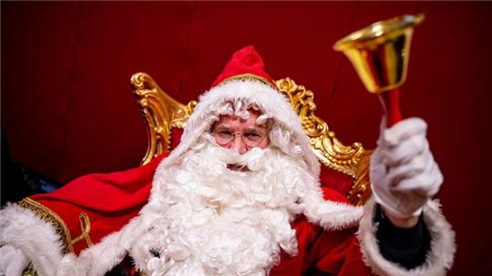 Hansjörg Rodewald als Weihnachtsmann verkleidet klingelt bei einem Workshop für neue Weihnachtsmänner mit einer Glocke.