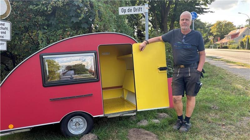 Diese Schneckenhaus-Wohnwagen aus dem Nachbarkreis sind kleine Raumwunder Tischler Harald Prien neben einem rot-gelbe Wohnwagen.