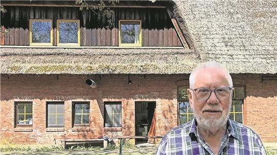 Hartmut Milter, ehrenamtlicher Vorstand des Jugend- und Bildungshauses, vor dem renovierungsbedürftigen Reetdach.