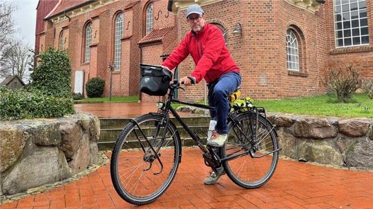 Hasnain Kazim legt vor der Kirche in Steinkirchen eine Pause auf seiner Deutschlandtour ein.
