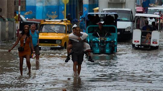 Havanna, Kuba: Nach Regenfällen steht die Straße kniehoch – Menschen waten durch die Fluten