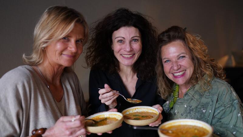 Haya Molcho (r-l), Abury-Gründerin Andrea Bury und Mitgründerin Petra Hoffmann halten eine Linsensuppe im 25 Hours Hotel Altes Hafenamt in der Hafencity in den Händen.