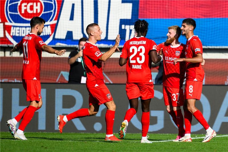 Heidenheims Jan-Niklas Beste (2.v.r) jubelt nach seinem Tor zum 4:2 mit der Mannschaft.