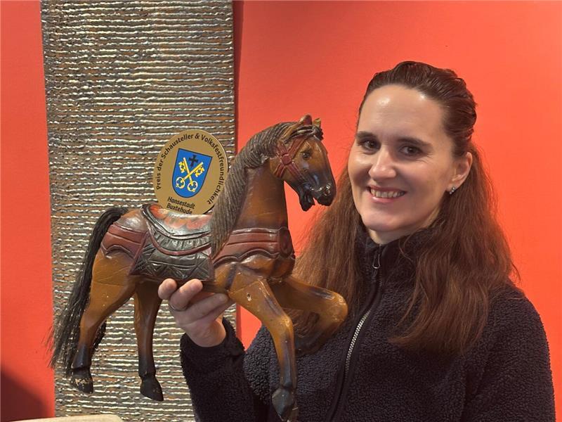 Heike Böttger vom Stadtmarketing Buxtehude zeigt die Figur eines mehr als 100 Jahre alten Jahrmarktpferdes. Damit hat der Schaustellerverband die Hansestadt Buxtehude für Volksfestfreundlichkeit ausgezeichnet.