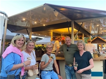 Heike Bremer (links) genießt mit einer Freundesgruppe aus den Nottensdorf und Hedendorf den lauschigen Platz am Weinstand in der Bergstraße.
