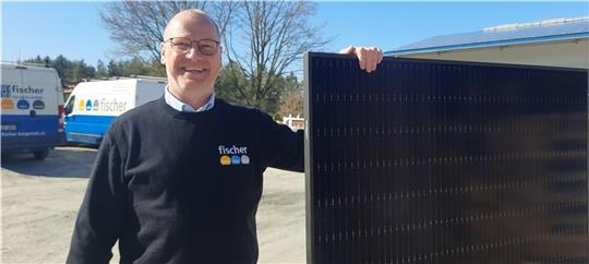 Heiko Fischer mit dem Modul einer Photovoltaikanlage: Mit Sonnenstrom kann die Wärmepumpe günstig laufen. Foto: Fehlbus