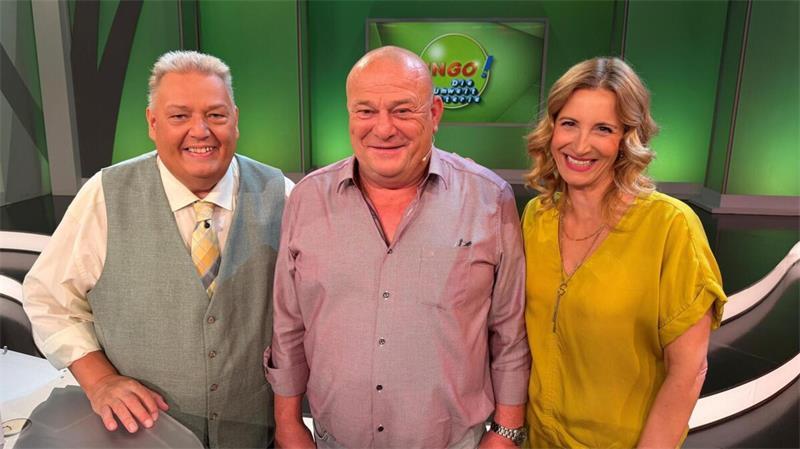 Heiko aus Hemmoor strahlt vor Freude nach seinem Gewinn in der NDR-Show „Bingo! – Die Umweltlotterie“, flankiert von den Moderatoren Michael Thürnau und Ilka Petersen.