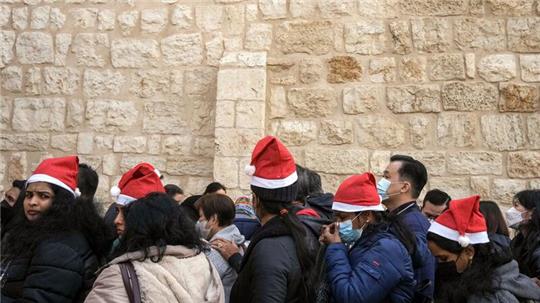 Heiligabend im vergangenen Jahr: Touristen - einige mit Weihnachtsmützen - stehen in Bethlehem vor der Geburtskirche Schlange.