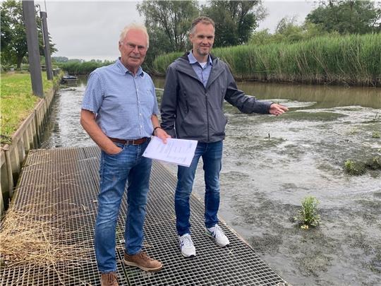Heinrich Reincke (links) und Peter Schley vom Deichverband Kehdingen- Oste zeigen auf den verschlickten Dornbuscher Hafen . Wenn er ausgebaggert wird, wäre er für den Deichbau geeignet. Foto: von Allwörden