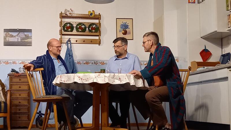 Aufregung um ein Klassentreffen mit De Hüller Theoterspeeler Heinz Holtmann (Rolf Kammann, rechts) und Nachbar Günter Gierig (Thomas Oellrich, links) sprechen mit Postbote Peter Specht (Matthias König, Mitte) über das anstehende Klassentreffen.