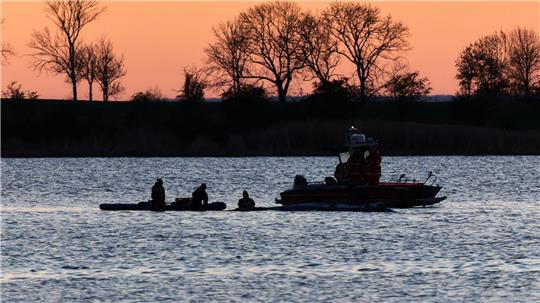 Helfer arbeiten in direkter Nähe des Wals. Der Buckelwal hat seine Position im flachen Wasser nicht wieder verlassen. 