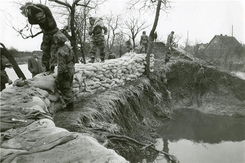 Helfer in der Not: Soldaten der Bundeswehr stapeln Sandsäcke nach einem Deichbruch an der Lühe. Fotos: Altländer Archiv/Jebramek