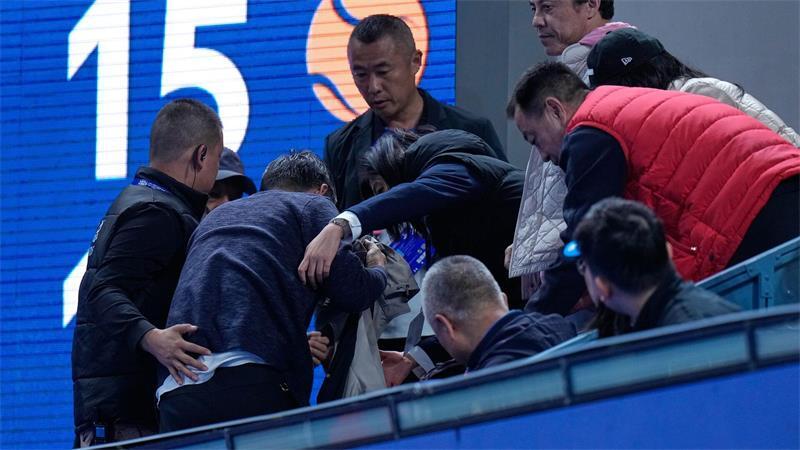 Helfer kümmern sich um einen Mann, der von einem Ball verletzt wurde, den der Russe Medwedew in die Zuschauerränge geschlagen hatte.