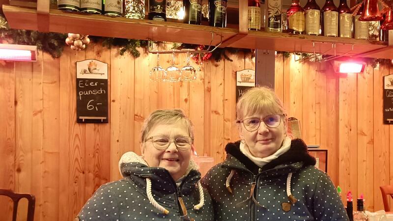 Helga Luttkau, hier mit Arbeitskraft Anja Kohn, hat 25-jähriges Jubiläum auf dem Stader Weihnachtsmarkt.