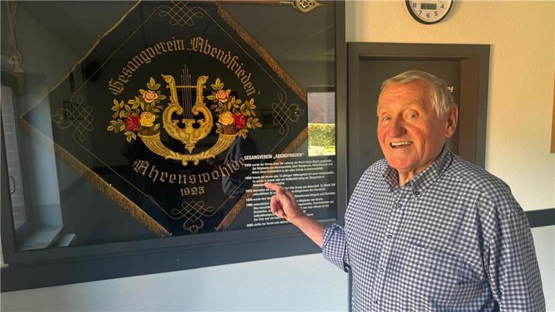 Helmut Meier vor der historischen Fahne des Ahrenswohlder Gesangvereins Abendfrieden.
