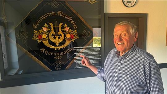 Helmut Meier vor der historischen Fahne des Ahrenswohlder Gesangvereins Abendfrieden.