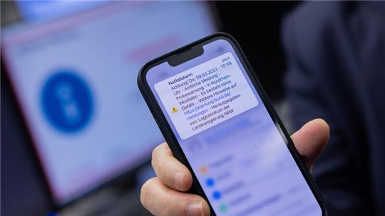 Herbert Reul (CDU), Innenminister von Nordrhein-Westfalen, zeigt sein Mobiltelefon, nachdem er den landesweiten Probealarm am Warntag per Mausklick im Lagezentrum der Landesregierung im Innenministerium ausgelöst hat.