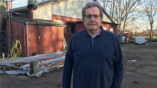 Hermann Bösch vor dem Schweinestall, auf dessen Dach noch immer ein Besen liegt.