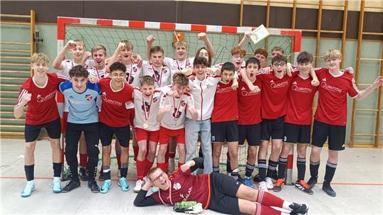Die JSG Geest U17 und 17 jubeln zusammen in einer Sporthalle vor einem Tor.