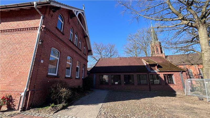 Hier soll das neue Pfarrhaus entstehen. Die Bestandsgebäude - das alte Pfarrhaus und der Gemeindesaal - müssen weichen.