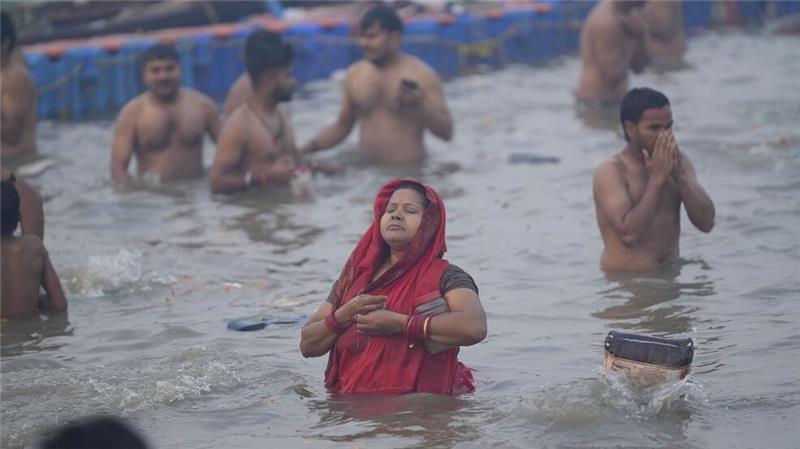 Hinduistische Gläubige nehmen am Neumondtag während des Maha Kumbh Mela Festivals ein heiliges Bad am Ufer des Sangam.
