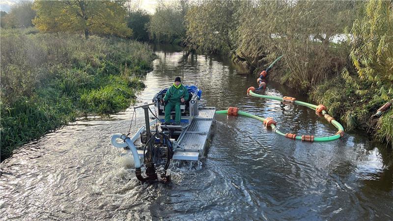 Amphibienfahrzeug auf der Aue: T50 kämpft gegen die Verstopfung Hinter dem Unterwasserstaubsauger hängt eine Rohrleitung. Der Sand aus der Aue wird 1,9 Kilometer weiter in ein Spülfeld an der K36 im Gewerbegebiet Horneburg gepumpt.