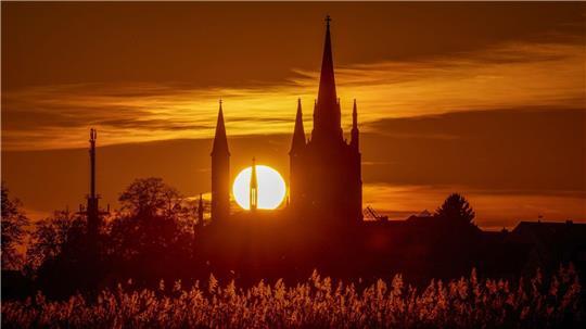 Hinter der Heilig-Geist-Kirche auf der Insel Werder geht die Sonne unter.