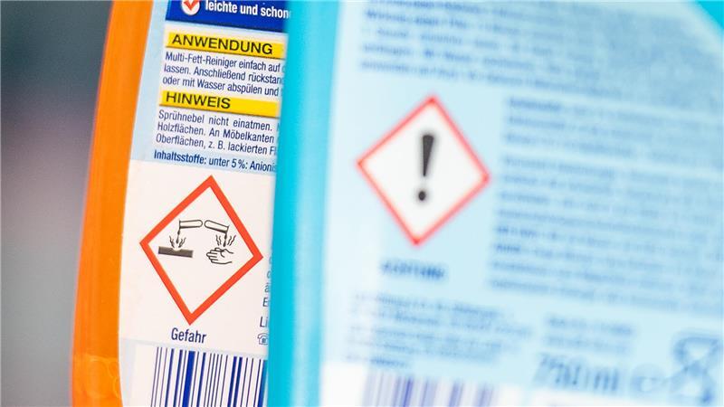 Hinweiszeichen auf Putzmittelverpackungen informieren über potenziell gefährliche Inhaltsstoffe.
