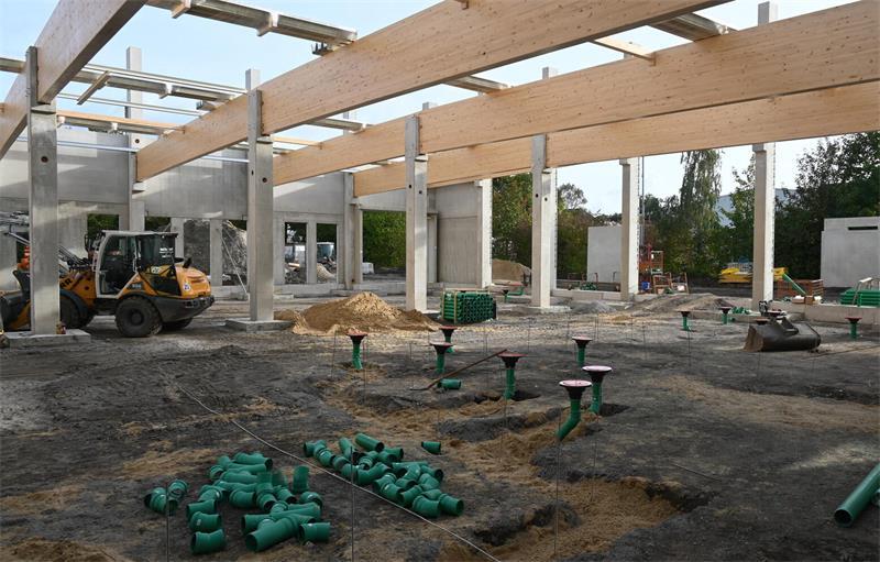 Ein Puzzle aus Beton und Stahl: So entsteht die Grundschule in Jork Hölzerne Dachbinder und darunter grüne Rohre: Hier entstehen die Duschen.