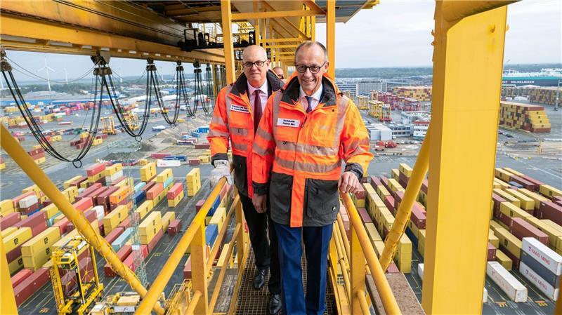 Hoffentlich schwindelfrei: Bundeskanzler Friedrich Merz und Bremens Bürgermeister Andreas Bovenschulte (SPD) stehen auf einer Containerbrücke im Überseehafen in Bremerhaven.
