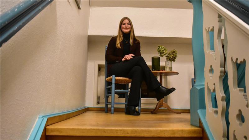 Sarah von Bargen sitzt auf einem Stuhl an einer Treppe im Mehrgenerationenhaus in Horneburg.