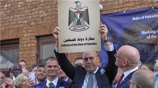 Husam S. Zomlot, Botschafter der palästinensischen Vertretung im Vereinigten Königreich, hält während einer Zeremonie zum Hissen der palästinensischen Flagge in der palästinensischen Vertretung ein neues Schild hoch. 