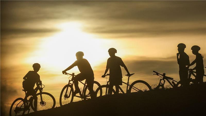 I want to ride my bicycle. Radfahrer machen eine Pause im Licht der Abendsonne auf den Philippinen. 