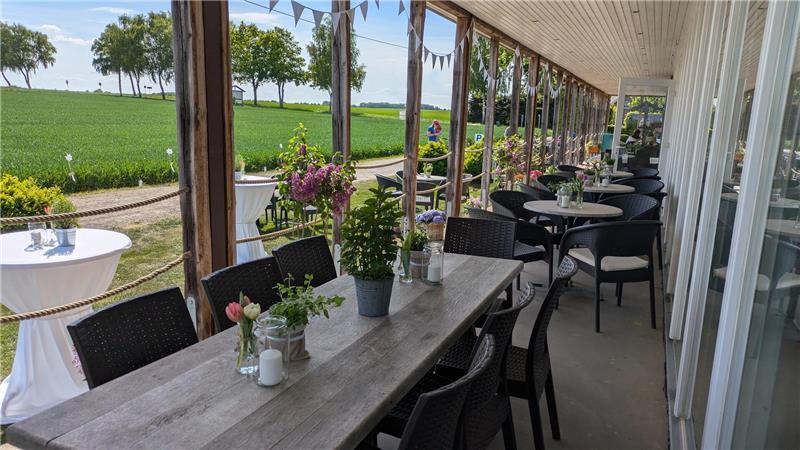 Hofcafé Tschritter in Nindorf: Labyrinth und leckere Torten Idyllischer Ausblick von der überdachten Veranda auf weite Wiesen und Getreidefelder.