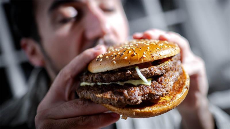 Illustration - Ein Mann beißt in einen Burger