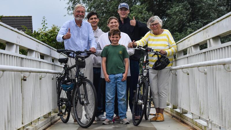 Die Familie Dürkes steht mit sechs Personen und zwei Fahrrädern auf einer Brücke.