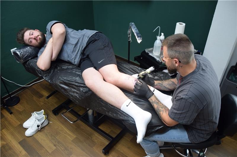 Im Atelier „Am Block Tätowierungen“ bringt Mitinhaber Johann (rechts) seinen Entwurf eines weißen Hais Stich für Stich auf die linke Wade von Johannes Fotos: Sulzyc