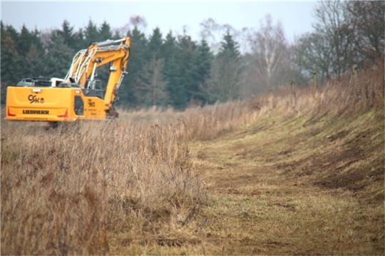 Im Auftrag der Bau- und Sandabbaufirma Bunte wird der Erdwall an der stillgelegten Sandkuhle am Schragenberg gemulcht. Foto: Vasel