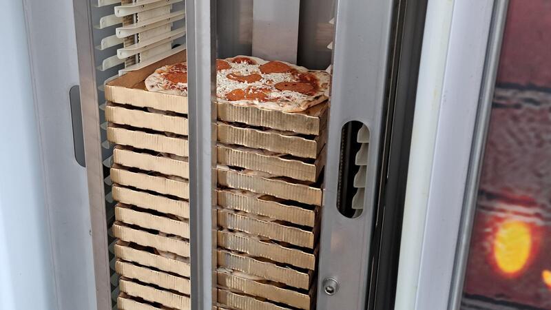 Im Automaten werden die Pizzen in einem Fach gelagert und bei Bestellung automatisch in den Ofen geschoben.