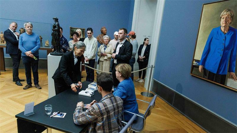 Im Bode-Museum signierte Merkel am Nachmittag Kunstpostkarten gemeinsam mit dem Maler ihres Porträts.