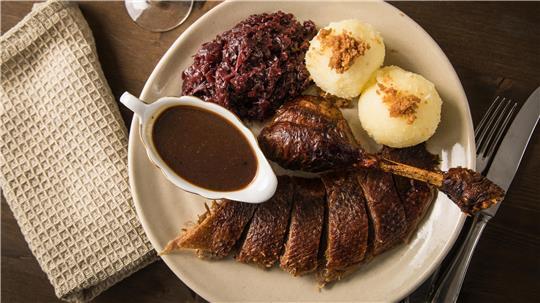 Rotkohl, Ente, Klöße und Soße auf einem Teller.