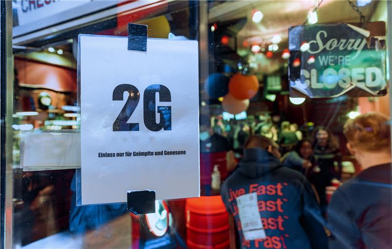 Im Fenster einer Kiez-Kneipe hängt ein Zettel mit dem Text "2G, Einlass nur für Geimpfte und Genesene". Foto: Markus Scholz/dpa