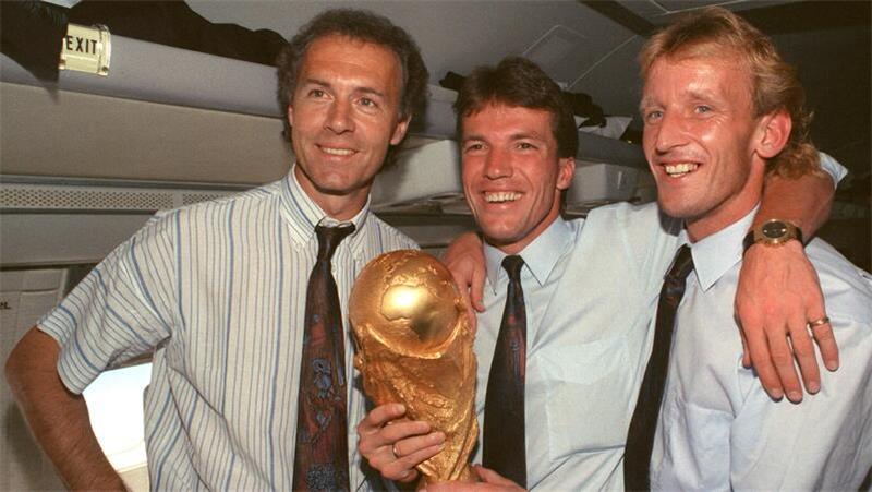WM-Held Andreas Brehme (63) plötzlich gestorben – „Treuen Freund verloren“ Im Flugzeug mit dem WM-Pokal: DFB-Teamchef Franz Beckenbauer (v.l.), Lothar Matthäus und Andreas Brehme.
